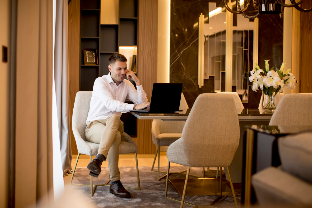 homme-affaires-assis-dans-chambre-luxueuse-devant-ordinateur-portable